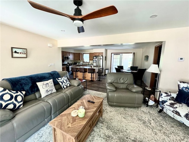 living room featuring ceiling fan and hardwood / wood-style flooring