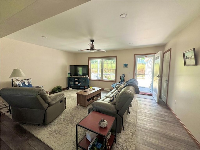 living room featuring ceiling fan and hardwood / wood-style flooring