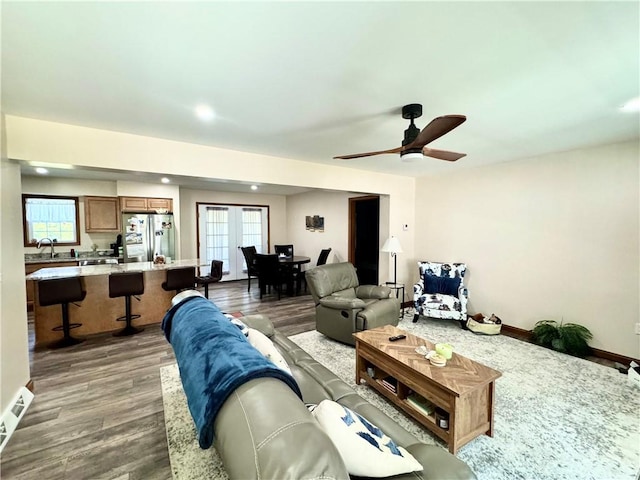 living room with ceiling fan, a healthy amount of sunlight, and dark hardwood / wood-style floors