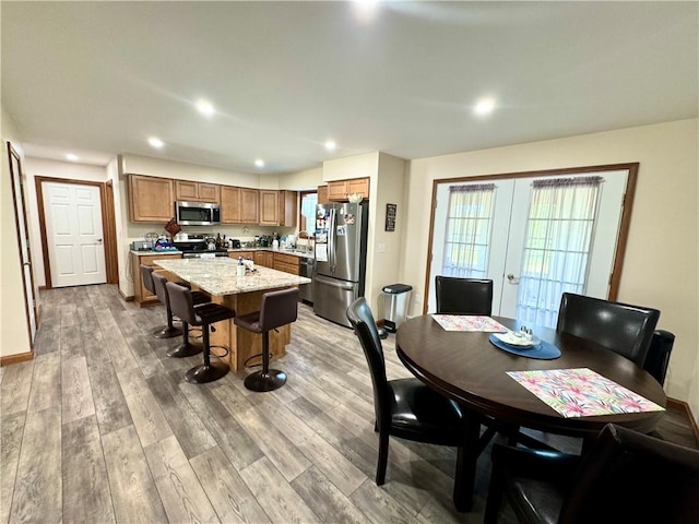 dining area featuring french doors, light hardwood / wood-style flooring, and sink