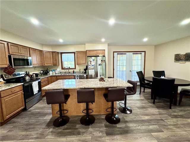 kitchen featuring a center island, sink, dark wood-type flooring, stainless steel appliances, and french doors