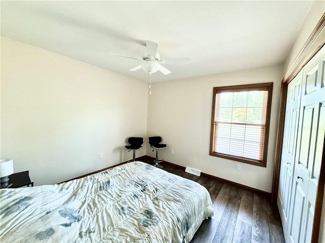 bedroom featuring ceiling fan, dark hardwood / wood-style floors, and a closet