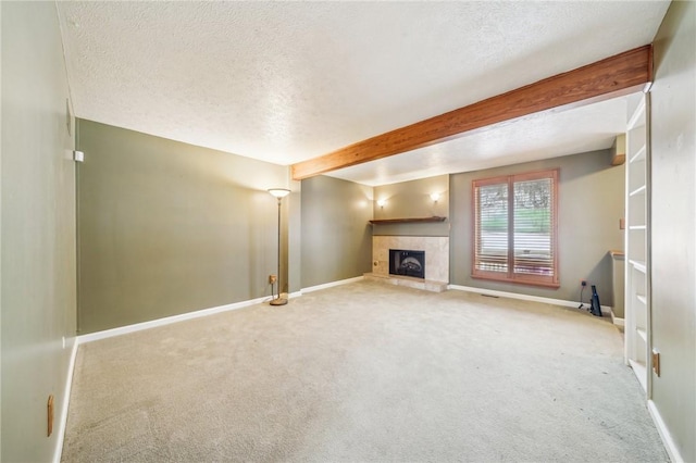 unfurnished living room featuring a textured ceiling, carpet, beamed ceiling, and a fireplace