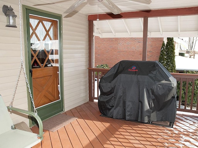 wooden deck with ceiling fan and area for grilling