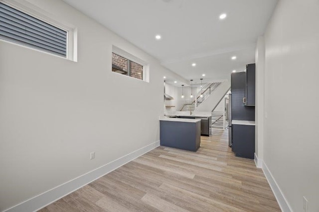 kitchen featuring light wood-type flooring, a center island, and decorative light fixtures