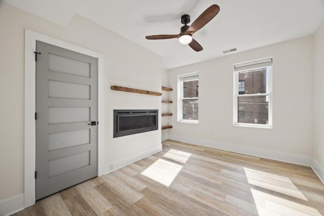 unfurnished living room featuring ceiling fan and light hardwood / wood-style flooring