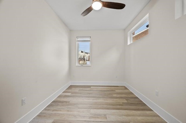 empty room featuring ceiling fan, light wood-type flooring, and a wealth of natural light