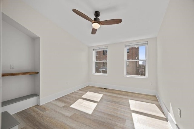 spare room with ceiling fan, lofted ceiling, and light hardwood / wood-style floors