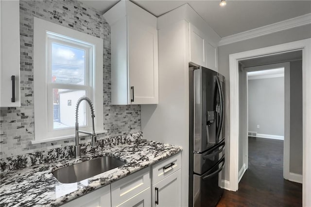 kitchen featuring tasteful backsplash, sink, white cabinetry, light stone countertops, and stainless steel fridge with ice dispenser