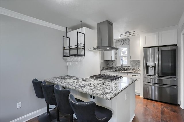 kitchen with island exhaust hood, appliances with stainless steel finishes, dark wood-type flooring, white cabinets, and light stone counters