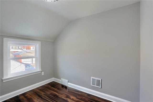 spare room with dark hardwood / wood-style floors and lofted ceiling