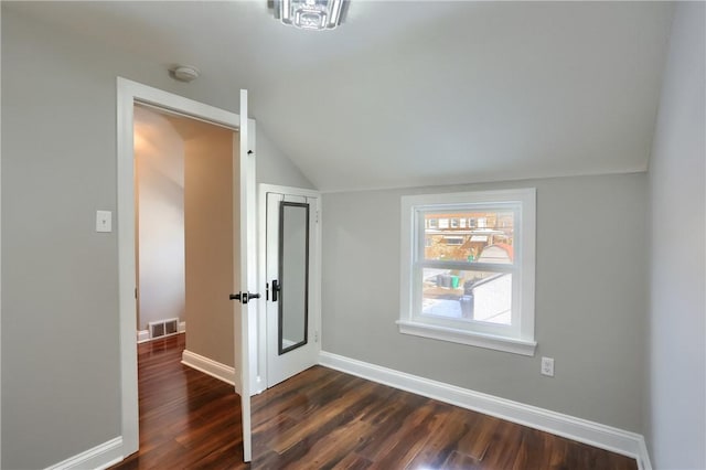 additional living space with dark wood-type flooring and vaulted ceiling