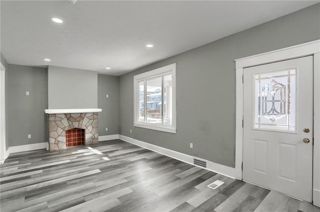 entryway with hardwood / wood-style floors and a fireplace