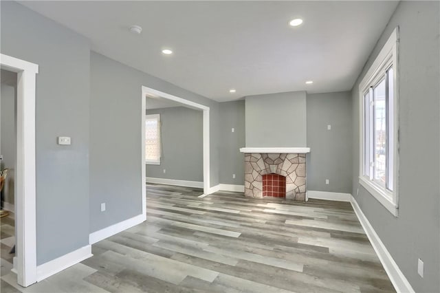 living room with a stone fireplace and light hardwood / wood-style floors