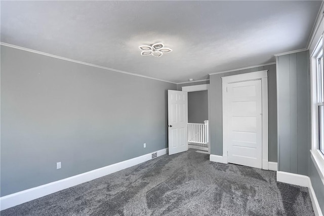 unfurnished bedroom featuring a closet, crown molding, and dark carpet