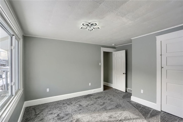 unfurnished bedroom with a textured ceiling and dark colored carpet