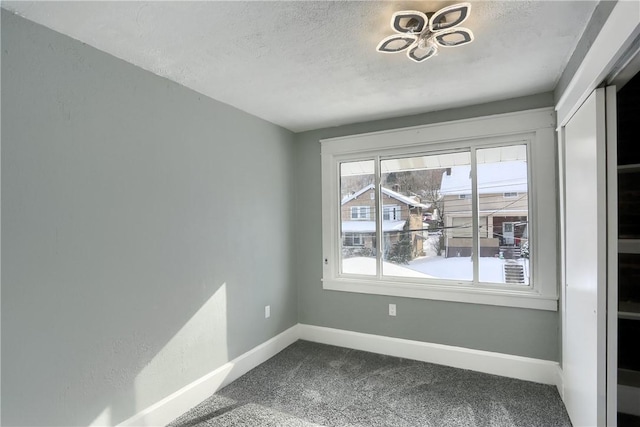 unfurnished room featuring a textured ceiling and carpet flooring