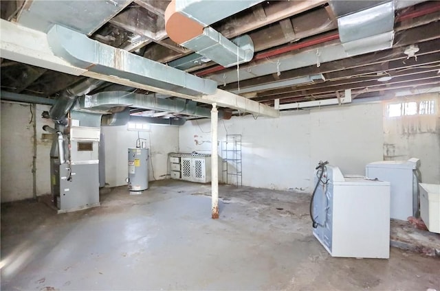 basement with water heater, separate washer and dryer, and heating unit