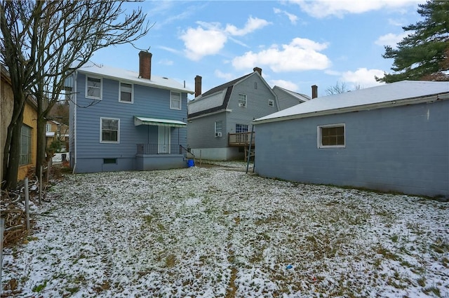 view of snow covered rear of property