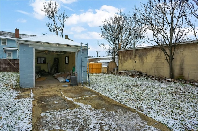 yard layered in snow featuring a storage unit