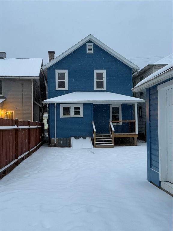 view of snow covered back of property