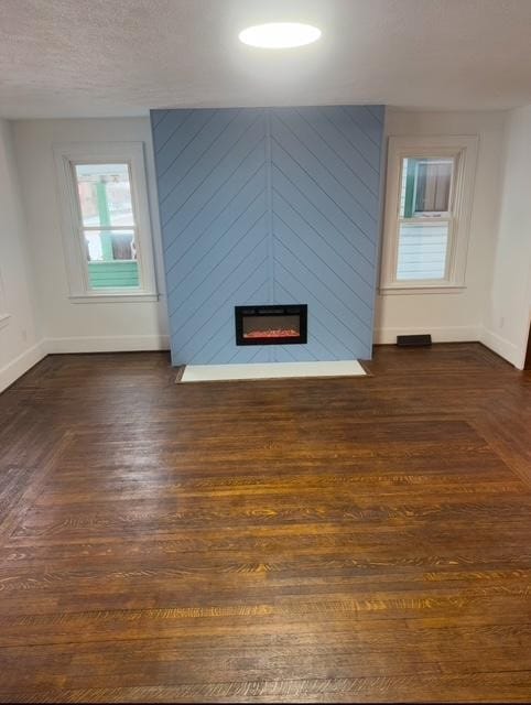 unfurnished living room with a fireplace and dark hardwood / wood-style floors