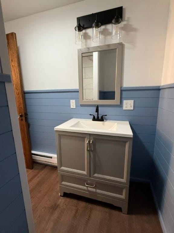 bathroom featuring hardwood / wood-style flooring, a baseboard radiator, and vanity