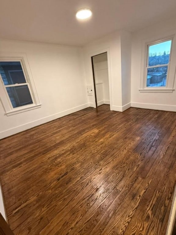 unfurnished room with dark wood-type flooring