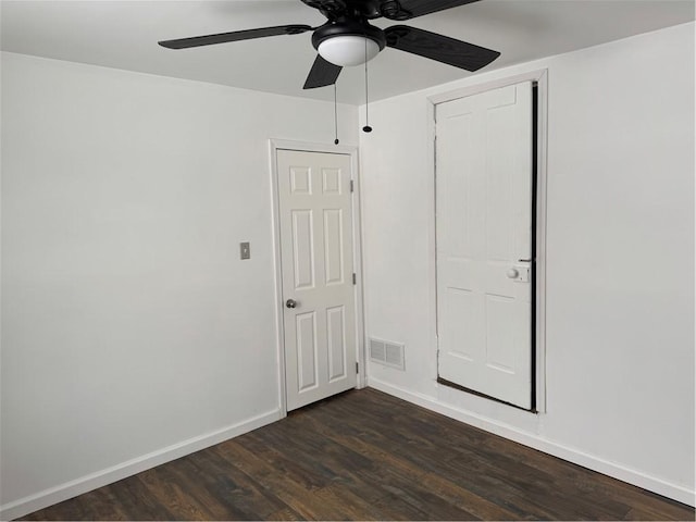 unfurnished bedroom with ceiling fan and dark wood-type flooring