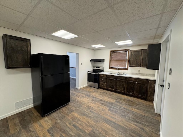 kitchen with stainless steel electric range oven, black fridge, dark hardwood / wood-style flooring, dark brown cabinetry, and sink