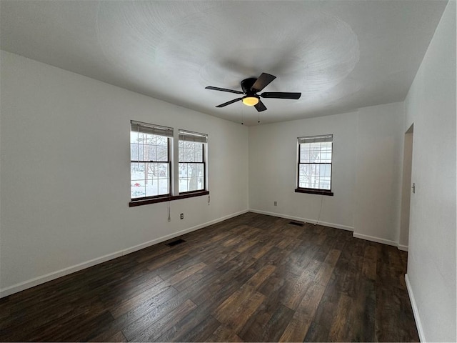 unfurnished room with ceiling fan, plenty of natural light, and dark hardwood / wood-style floors