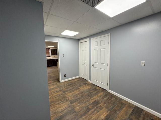 corridor featuring a drop ceiling and dark hardwood / wood-style floors