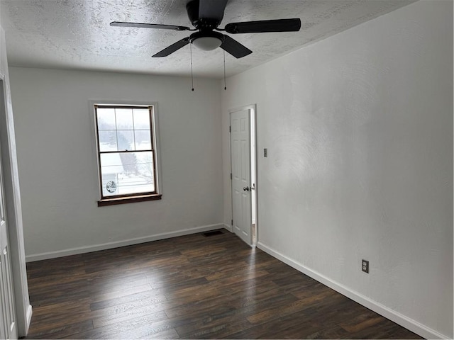 spare room with ceiling fan, a textured ceiling, and dark hardwood / wood-style floors