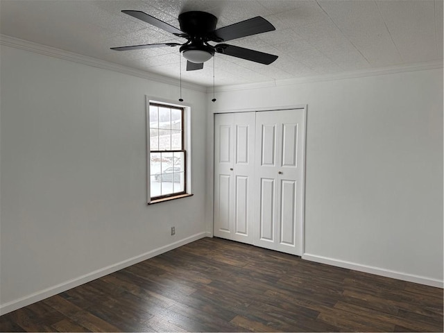 unfurnished bedroom featuring ceiling fan, dark wood-type flooring, a closet, and ornamental molding