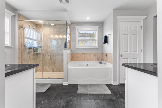 bathroom featuring a healthy amount of sunlight, separate shower and tub, and vanity