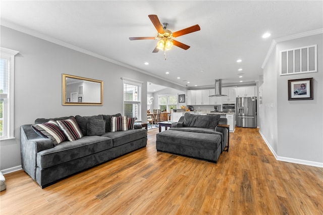 living room featuring ceiling fan, light hardwood / wood-style flooring, and crown molding