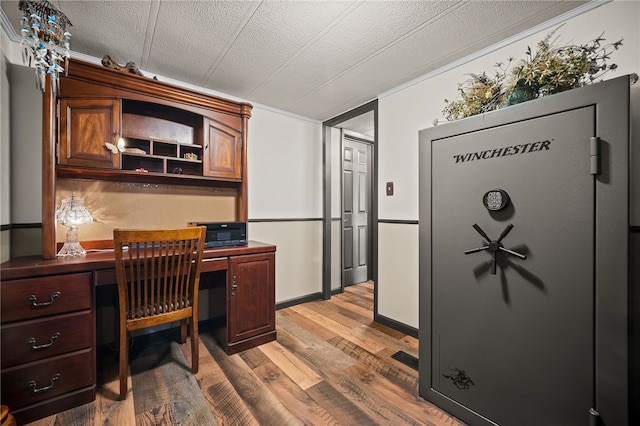 office area with built in desk, a textured ceiling, and light hardwood / wood-style flooring