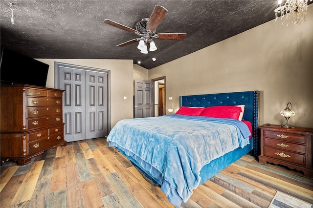 bedroom featuring ceiling fan, wood-type flooring, a closet, and lofted ceiling