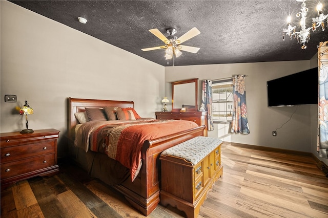 bedroom with ceiling fan, light hardwood / wood-style floors, and lofted ceiling