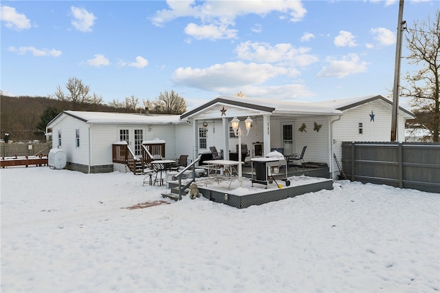 snow covered property featuring a deck