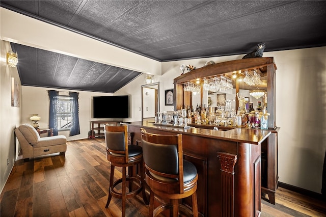 bar with vaulted ceiling and hardwood / wood-style flooring