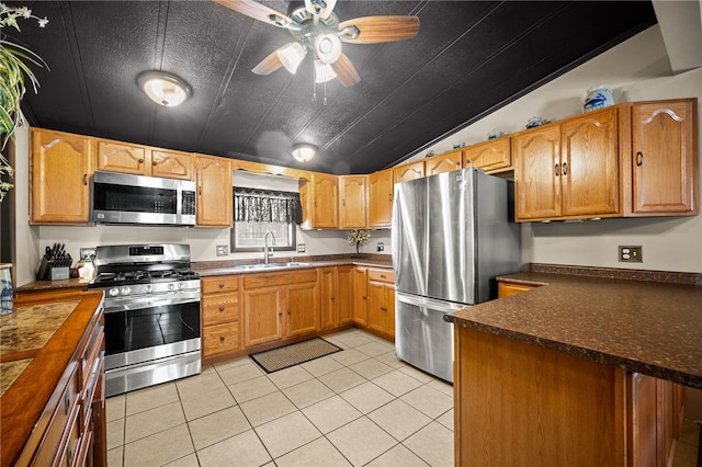 kitchen with ceiling fan, sink, appliances with stainless steel finishes, and light tile patterned flooring