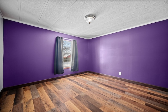 spare room with wood-type flooring and a textured ceiling