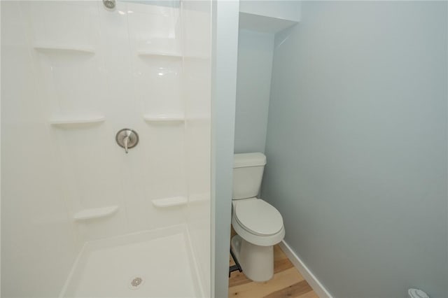 bathroom with toilet, a shower, and hardwood / wood-style flooring