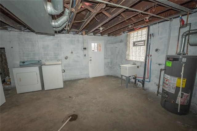 basement featuring water heater, washer and clothes dryer, and sink