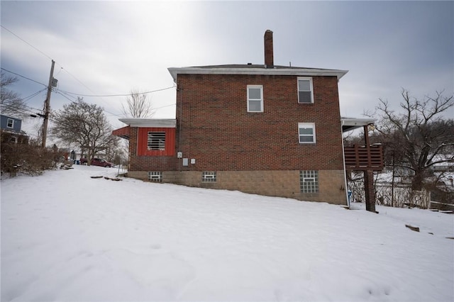 view of snow covered back of property