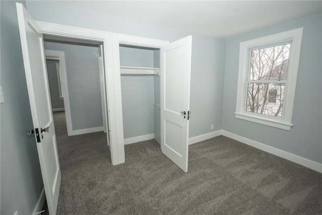 unfurnished bedroom featuring a closet and dark colored carpet