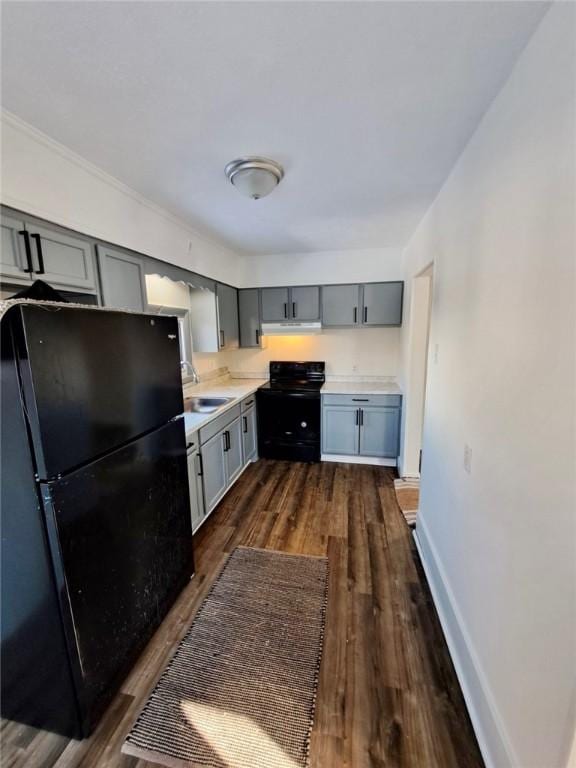 kitchen with ventilation hood, gray cabinetry, dark hardwood / wood-style floors, black appliances, and sink