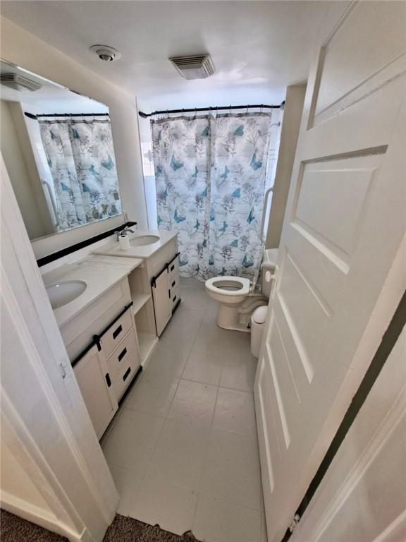 bathroom with toilet, vanity, and a shower with shower curtain