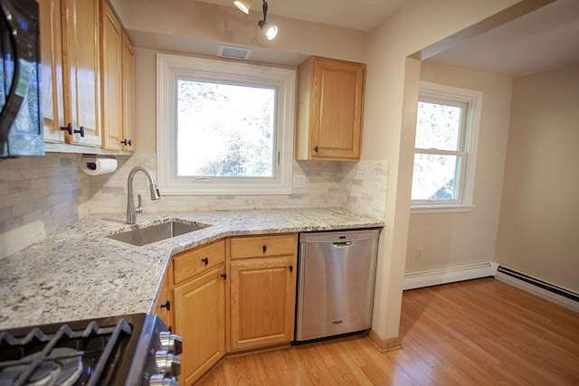 kitchen with tasteful backsplash, sink, light hardwood / wood-style flooring, light stone countertops, and stainless steel appliances